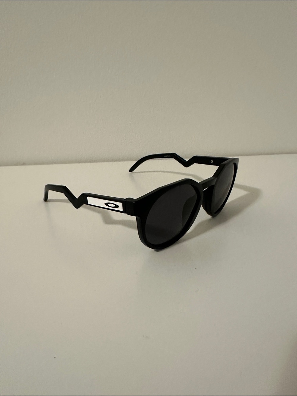 Oakley Black Round Sunglasses with Zigzag Temples and White Logo Accents
